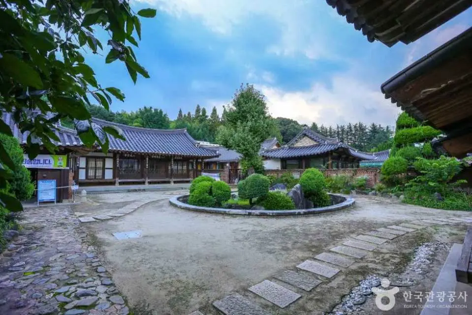 광주 양림동 전통 한옥 마을의 아름다운 정원. 돌길이 원형 조경을 둘러싸고 있어 고요한 한국 전통 생활 분위기를 느낄 수 있습니다.