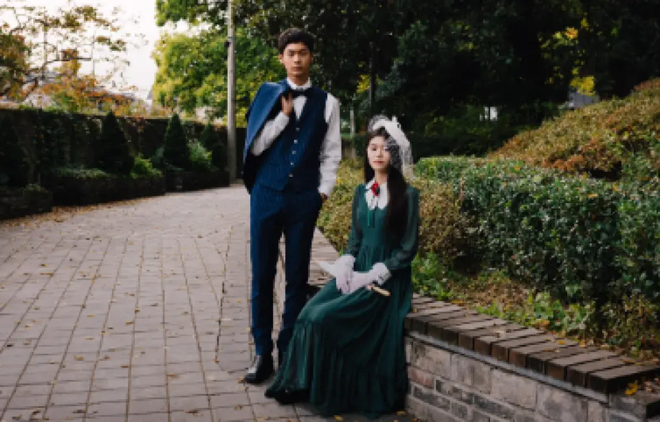 1930년대 스타일의 복고풍 의상을 입은 젊은 남녀가 광주 옛 골목을 산책하며, 시간 여행을 하는 듯한 특별한 여행 사진 촬영의 즐거움을 경험합니다.