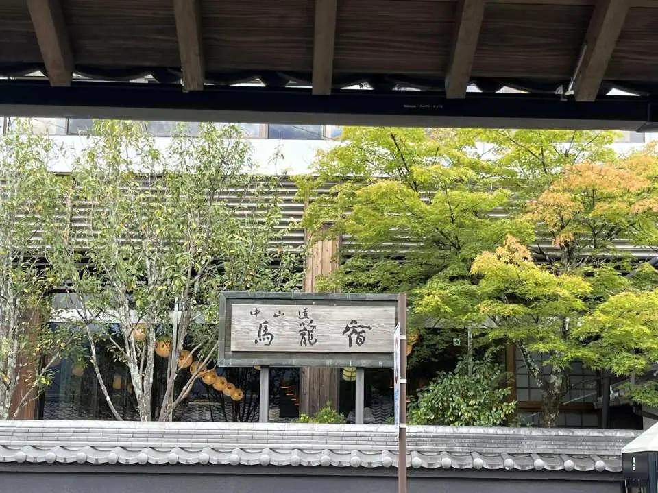 馬籠宿は、江戸時代に中山道沿いに造られた69ヶ所の宿場のうち43番目に建てられたもので、江戸の中山道の起点である日本橋から約332キロメートル離れた場所に位置しています。急峻な山道沿いに石造りで建てられた宿場には、本宿、脇宿、宿場、そして中央には小さな食堂が並んでいました。徳川家康が日本を統一した後、江戸（東京）から5つの街道を建設し、道路建設に着手しました。全長540キロメートルの中山道は商人にとって重要なルートとなり、その中間地点に位置する妻籠宿と馬籠宿は、この2つの小さな町の繁栄に貢献しました。馬籠宿通りは今も当時の石畳が敷き詰められ、両側の木造家屋には様々な商店が軒を連ねています。茶屋、居酒屋、美術品店、旅館などが昔ながらの魅力にあふれています。どの店にも色とりどりの花が植えられており、昔ながらの井戸や水車がそのまま残っている店もあり、古き良き時代の雰囲気を醸し出している。ノスタルジックな街並みを散策していると、時折、伝統的な着物を着た老婦人に出会うことがあり、まるでタイムトンネルに入り、17世紀の徳川家康の時代にタイムスリップしたような気分になる。