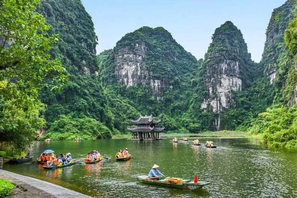 1. At Trang An Eco-Tourism Complex, embark on a scenic boat ride through serene waterways surrounded by majestic limestone cliffs. Glide past peaceful rice paddies, tranquil streams, and lush green fields. Discover mysterious caves such as Sang, Toi, Ba Giot, and Nau Ruou, immersing yourself in the untouched beauty often called the ‘Ha Long Bay on land.’