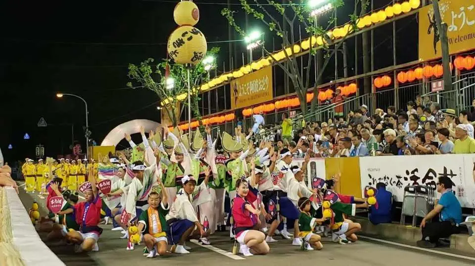 【南內町演舞場】
南內町演舞場位於德島市中心，是「阿波舞祭」期間最具代表性的主要付費觀賞舞台之一，也是歷年祭典中人氣最高的演舞場之一。每年8月12日至15日阿波舞祭期間，來自德島各地的專業舞團與「連（Ren）」隊伍會在此輪番登場，展現整齊劃一又充滿活力的傳統舞蹈表演。
演舞場採專用觀覽席設計，能讓觀眾近距離欣賞舞者的動作細節與現場音樂節奏，充分感受阿波舞「跳舞的阿呆、觀看的阿呆」所傳達的熱情氛圍。夜間場次燈光與音樂交織，更營造出熱烈且震撼的祭典現場感受。
作為阿波舞祭的重要核心會場，南內町演舞場是體驗德島夏季文化與傳統節慶魅力的最佳地點之一。