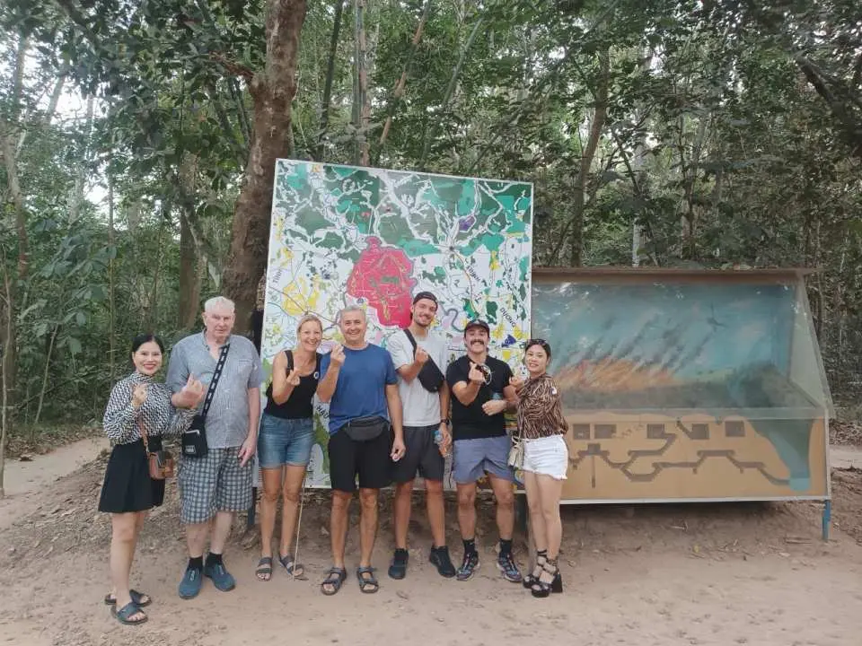 旅客在胡志明市古芝隧道景點的解說區，觀看地道模型與相關歷史壁畫，了解其複雜結構。