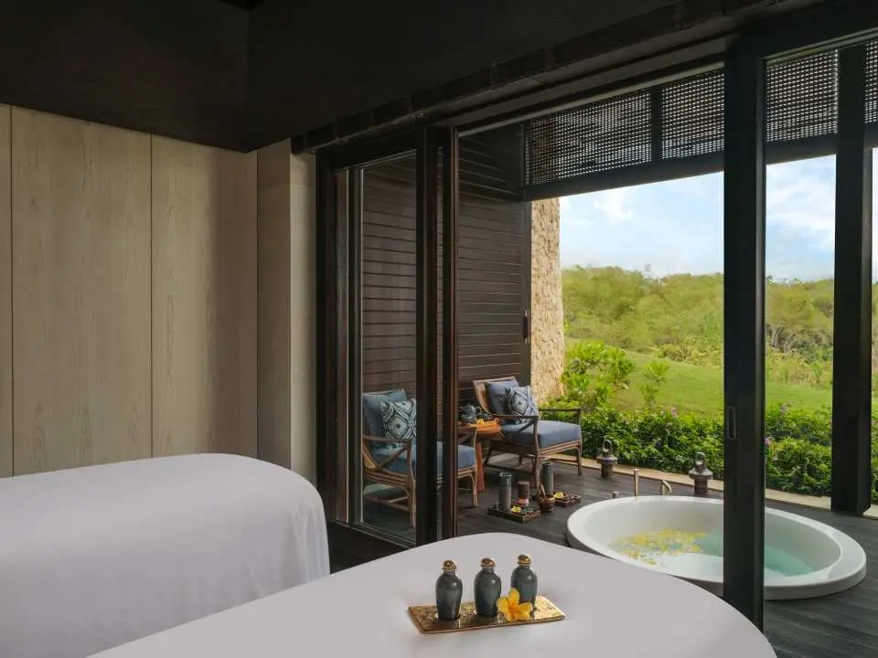 Luxurious double spa room at Raffles Bali Spa, featuring a private balcony, outdoor plunge pool, and tropical garden, offering an intimate and comfortable relaxation space.