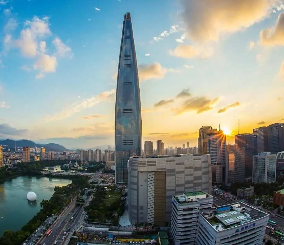 首尔标志性建筑乐天世界塔在夜晚璀璨发光，与汉江上桥梁的灯光和城市天际线交相辉映，是搭乘包车欣赏首尔繁华夜景的绝佳视角。