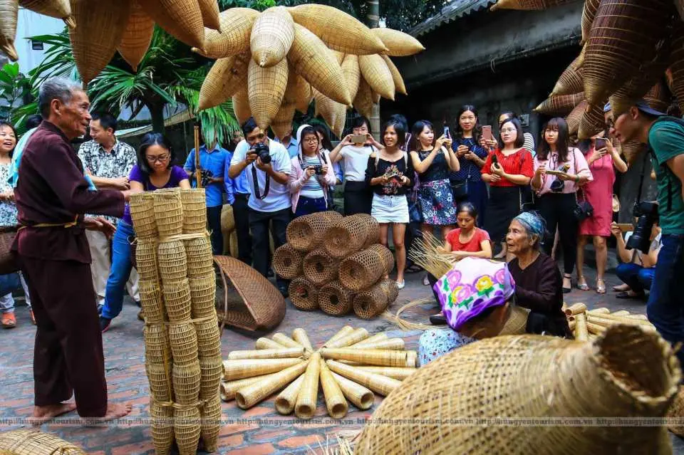 Tại Làng Lồng Bắt Cá, Việt Nam, những người dân làng giàu kinh nghiệm đang trình diễn cách làm lồng bắt cá truyền thống cho du khách tò mò, họ chăm chú theo dõi và tương tác, hiểu sâu hơn về văn hóa đánh bắt cá địa phương.