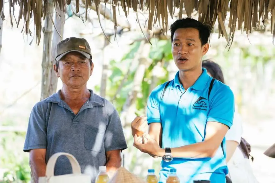 Local farmer and guide at Hoi An farm introducing sustainable farming and composting knowledge to visitors.