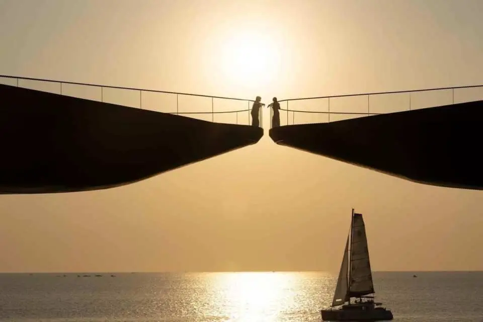 富国岛日落时分，远方鸿桥（Kiss Bridge）上的剪影情侣与海面上的尼莫游艇相映成趣。
