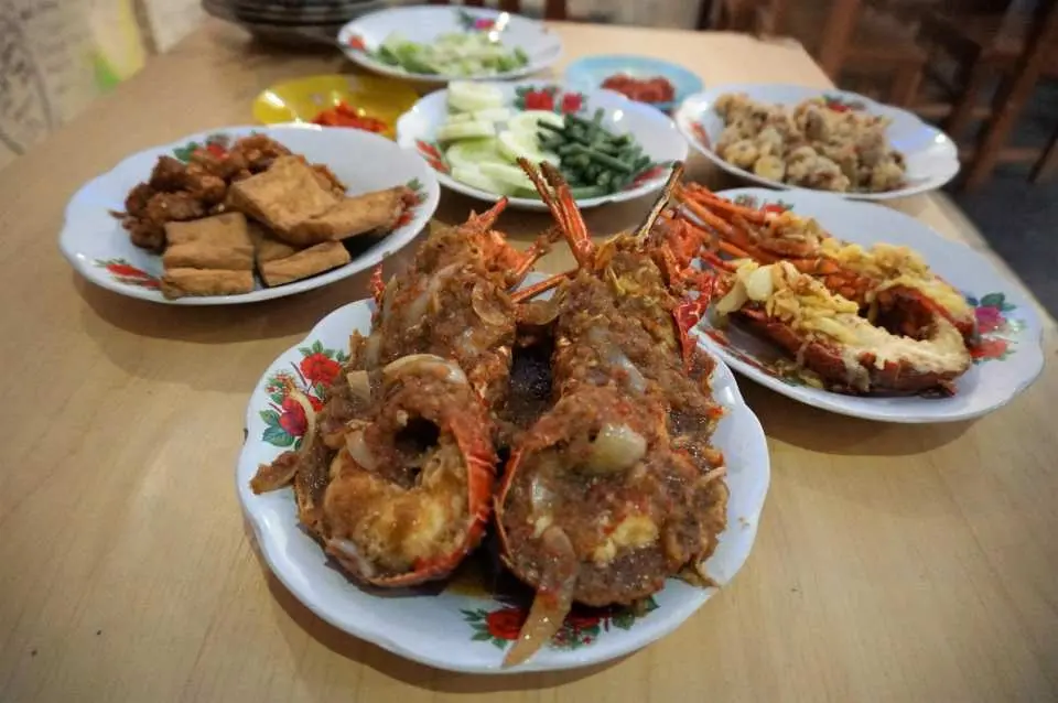 นักท่องเที่ยวรับประทานอาหารกลางวันเป็นกุ้งล็อบสเตอร์ที่หมู่บ้านทิมัง หลังจากเที่ยวชมหาดทิมัง ในบรรยากาศเรียบง่ายของหมู่บ้านริมทะเล