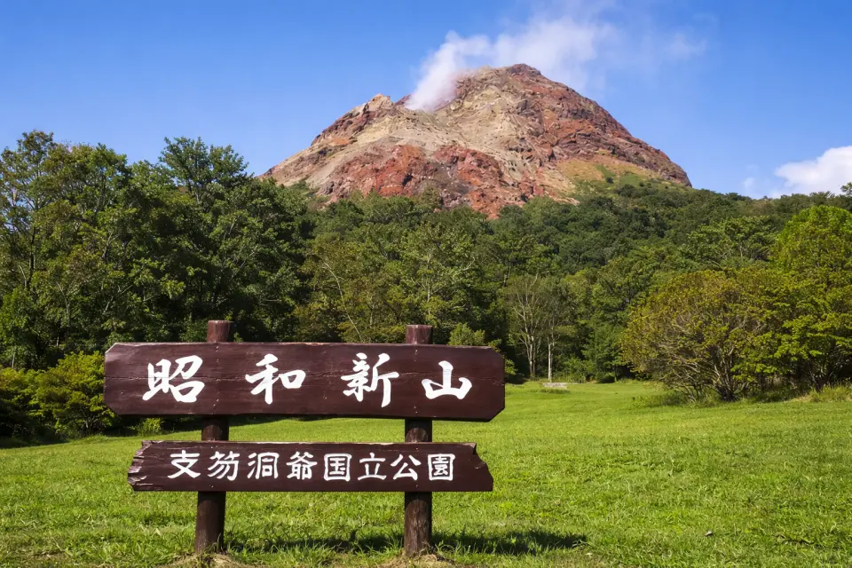 昭和新山：北海道著名的活火山景點，由1943年火山活動形成，至今仍可見白煙緩緩升起。冬季白雪覆蓋山體，與火山地形形成獨特景觀，是北海道必訪的自然奇觀。