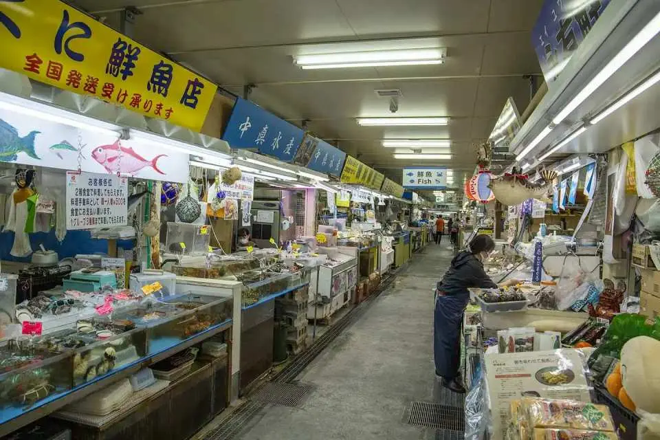 【第一牧志公設市場】被稱為「沖繩人的廚房」，是一處能深入體驗在地飲食文化的熱鬧市場。一樓販售各式新鮮海產與特色食材，二樓可現點現煮，品嚐最道地的沖繩風味。熱情的攤販與繽紛食材交織出最真實的那霸日常風景。