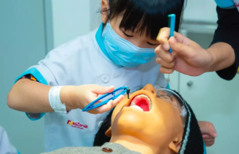 Child role-playing as a dentist and doing a dental checkup for a patient
